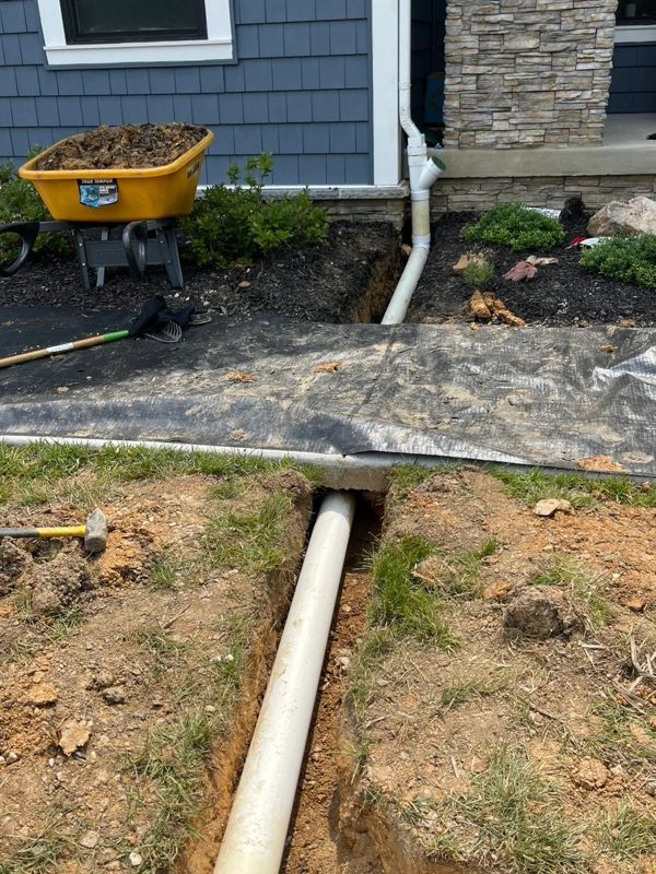 Downspout tied into buried PVC to carry water away from the house