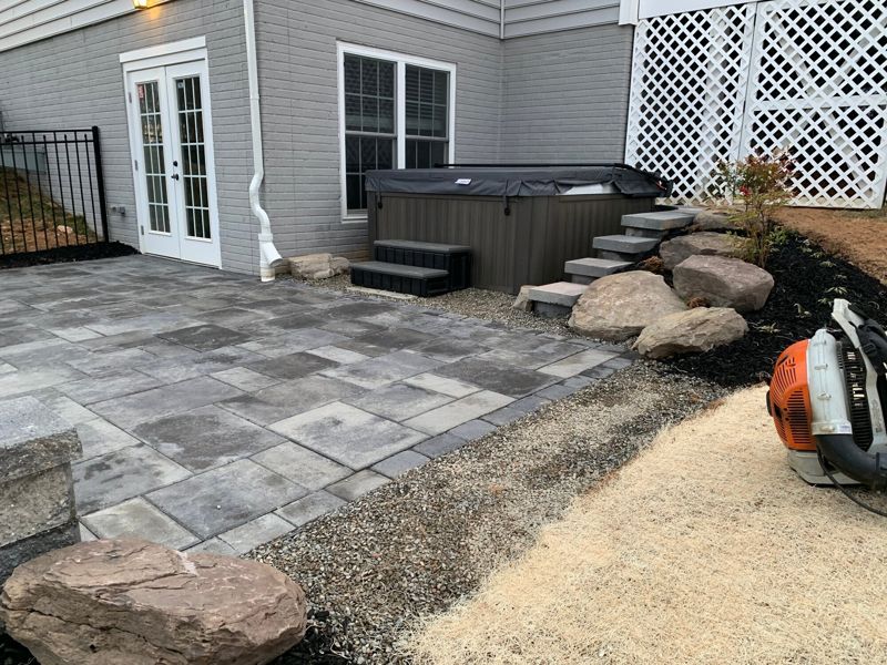 Paver patio with boulder steps and a hot tub pad