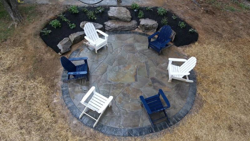 Circular flagstone patio with a paver border and new plantings
